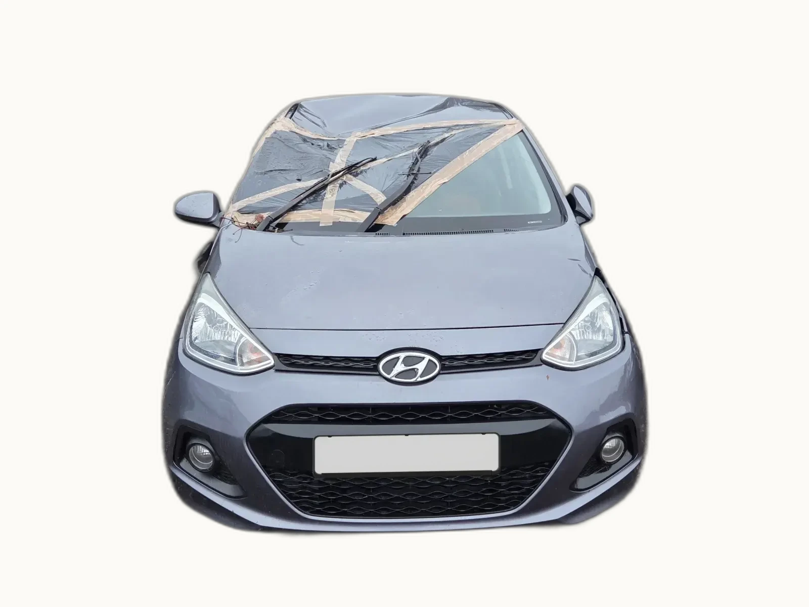 Grey Hyundai i10 photographed head-on with a smashed windscreen temporarily taped over, the kind of in-progress damage assessment the ABI Code categorises
