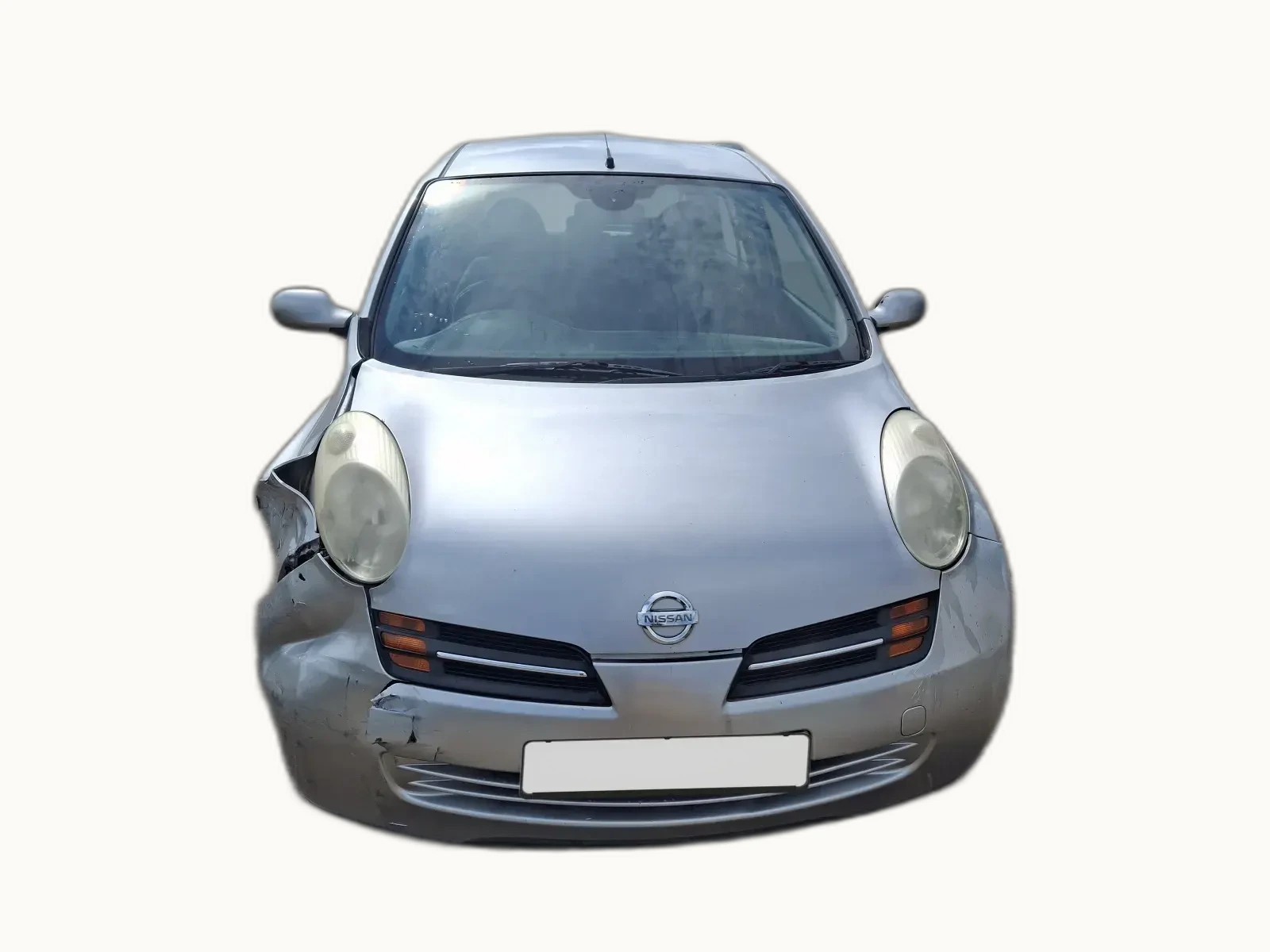 Silver Nissan Micra photographed head-on with light front-end damage. A scuffed bumper and small dent to the lower wing, bonnet and headlights intact