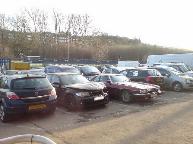 A crash-damaged hatchback among cars awaiting assessment at an accident repair centre in Leeds